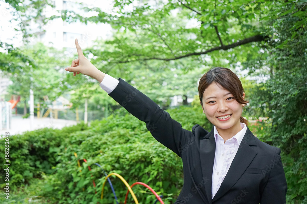 Businesswoman pointing to upside outdoors Businesswoman pointing to upside outdoors