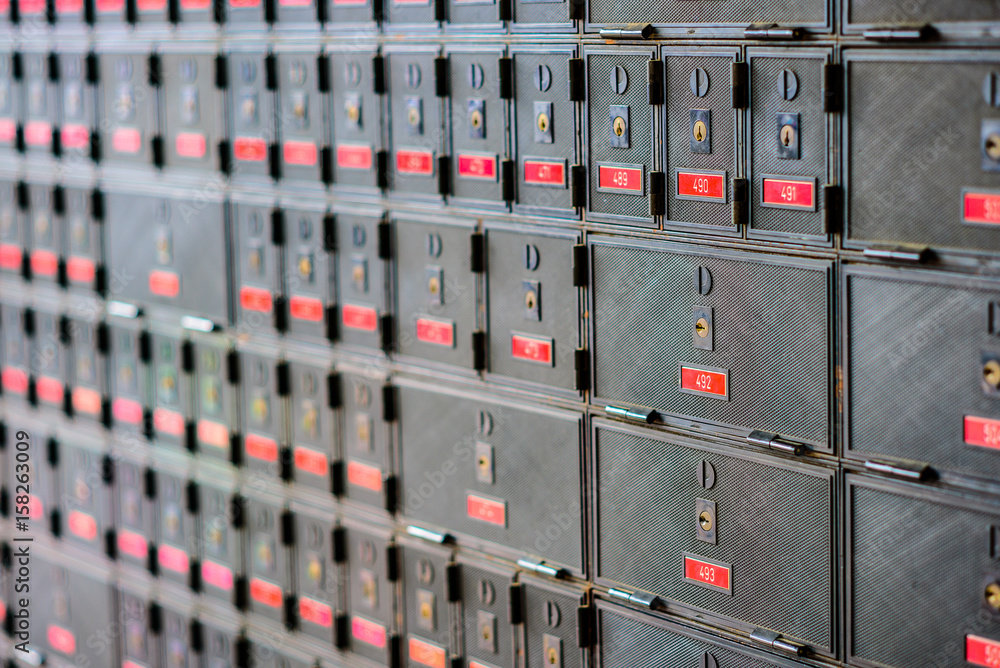 Rows of many locked post office boxes with red number labels Rows of many locked post office boxes with red number labels