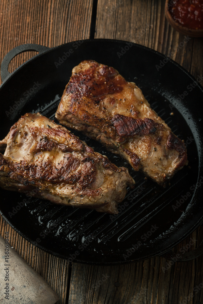 Grill Pork ribs with ketchup, mustard in a frying pan Grill Pork ribs with ketchup, mustard in a frying pan