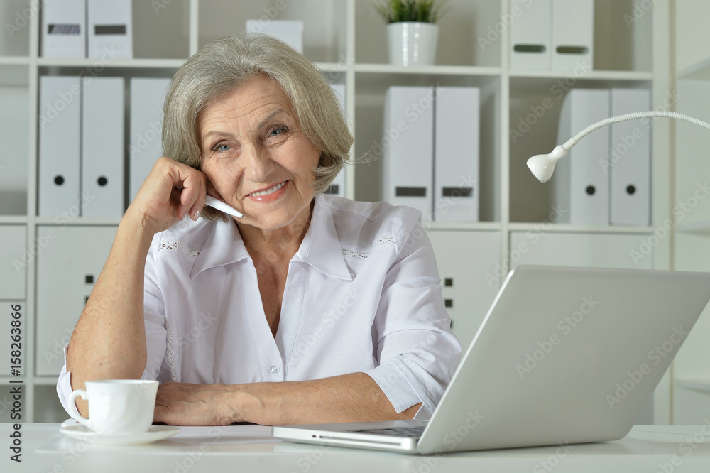 Old business woman with laptop working Old business woman with laptop working