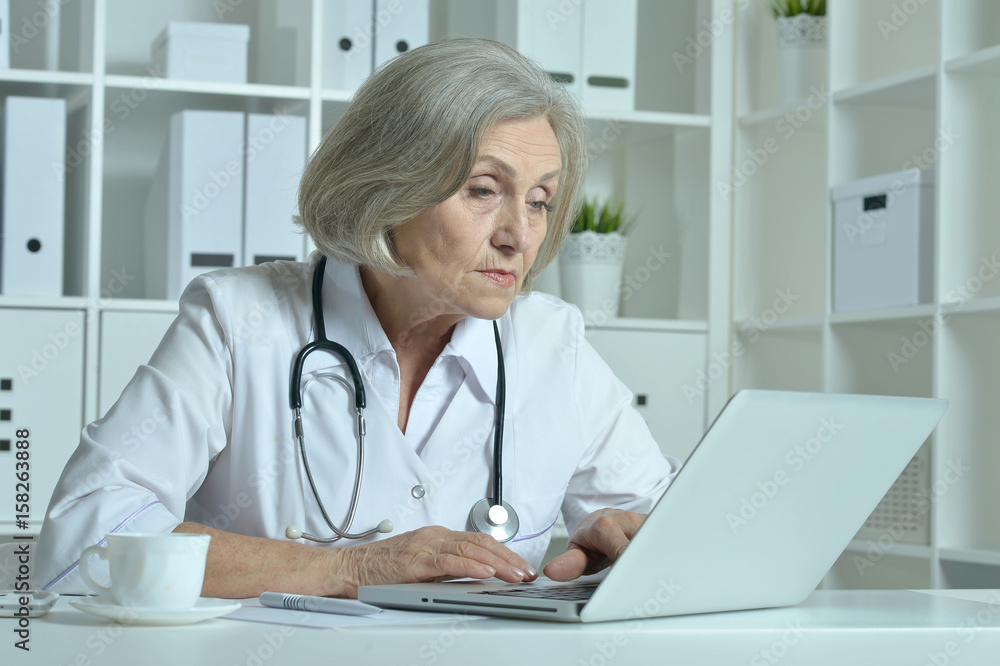 Old doctor with a laptop working Old doctor with a laptop working