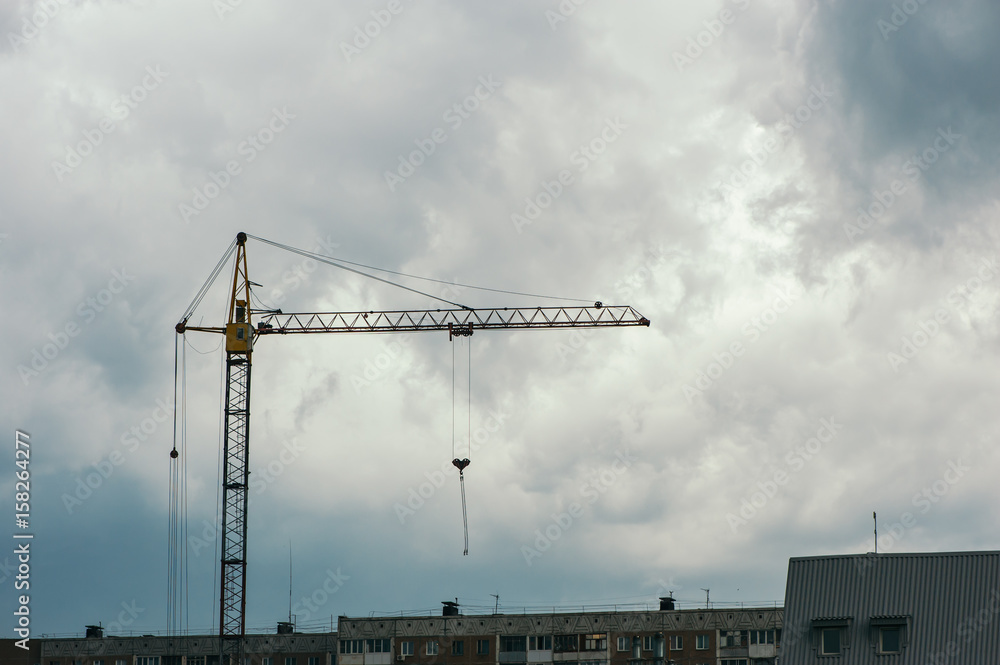 Crane over a cloudy sky background. Construction in the city. Industry. Crane over a cloudy sky background. Construction in the city. Industry.