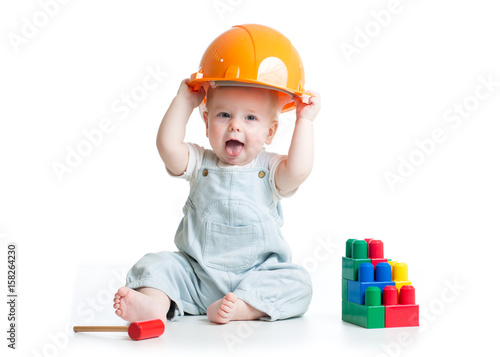 Baby in hardhat playing toys isolated on a white background.