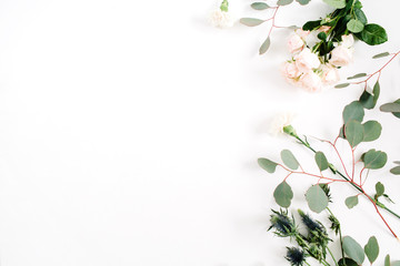 Beige rose flowers, eringium flower, eucalyptus branches on white background. Flat lay, top view. Floral background
