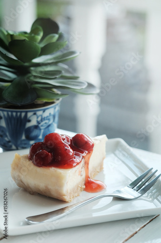 Принти на полотні A piece of cherry cheesecake on white wooden table