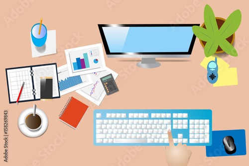 Top view of office desk with supplies, computer monitor and keyboard. Hand is touching computer keyboard.