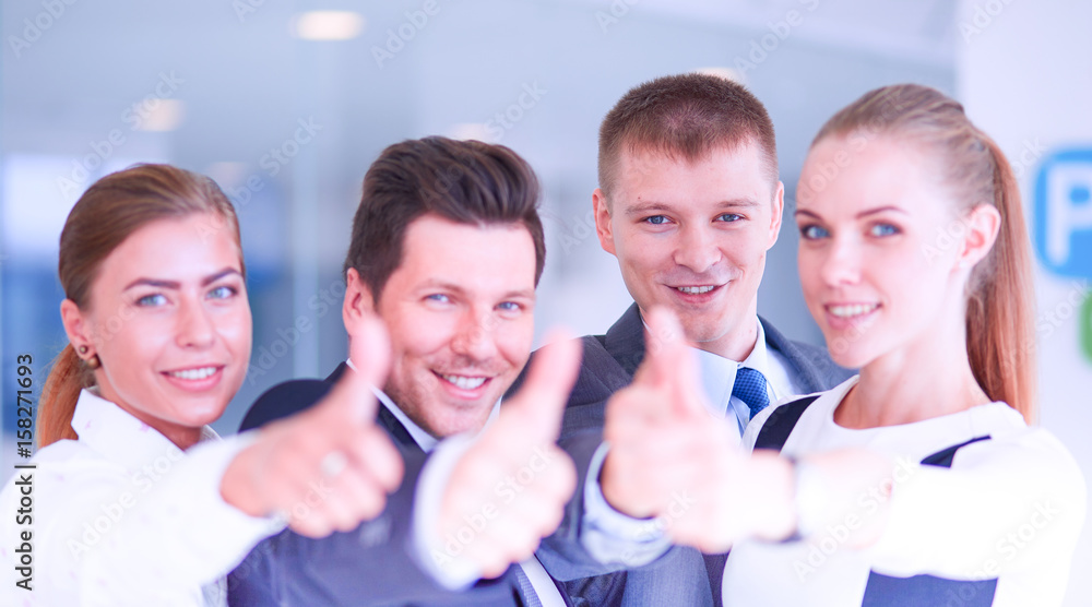 Obraz premium Happy business team showing thumbs up in office