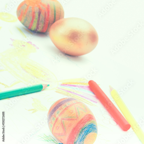 Painted eggs and pencil on white background photo