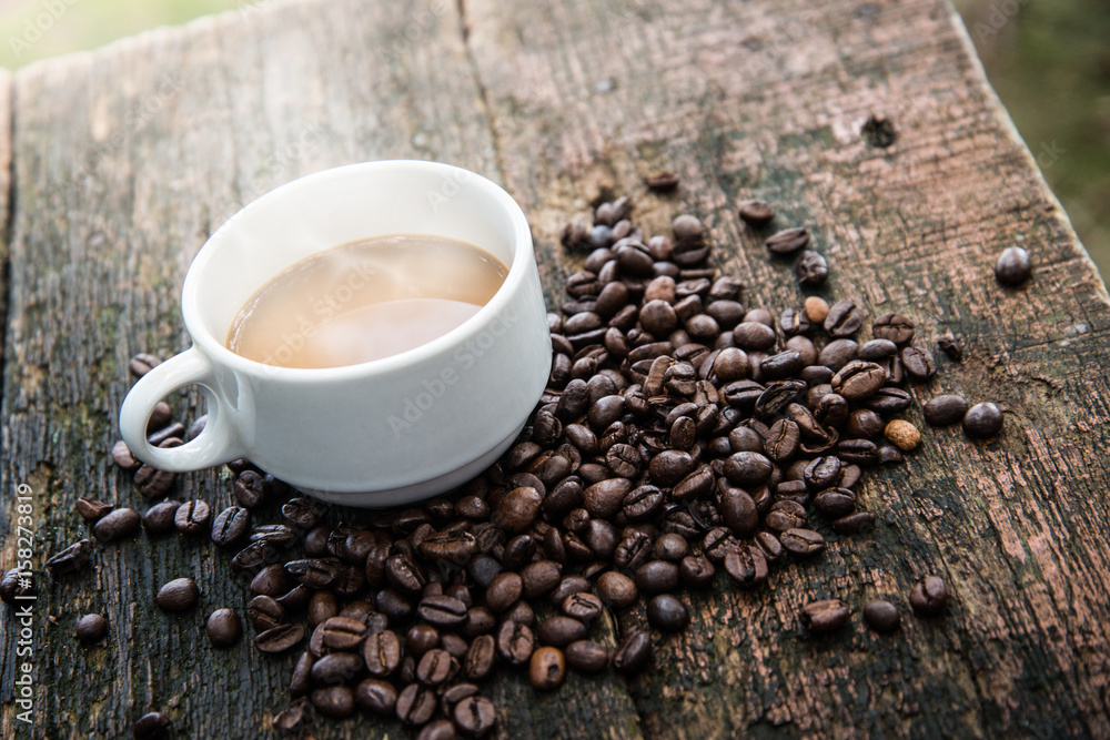 Obraz premium Hot cub of coffee and bean on wooden background