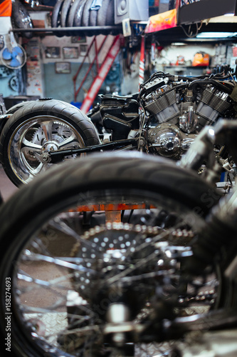 Row of disassembled motorcycles set for tuning up and customizing in mechanics workshop