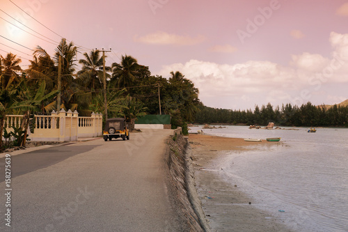 Tropical Seychelles. Palm trees and Indian Ocean of Praslin Island at sunset.