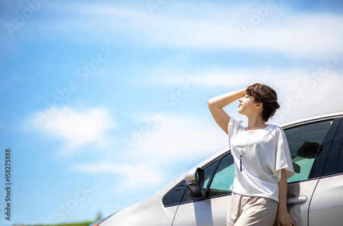 woman driver and vehicle under the blue sky. © metamorworks