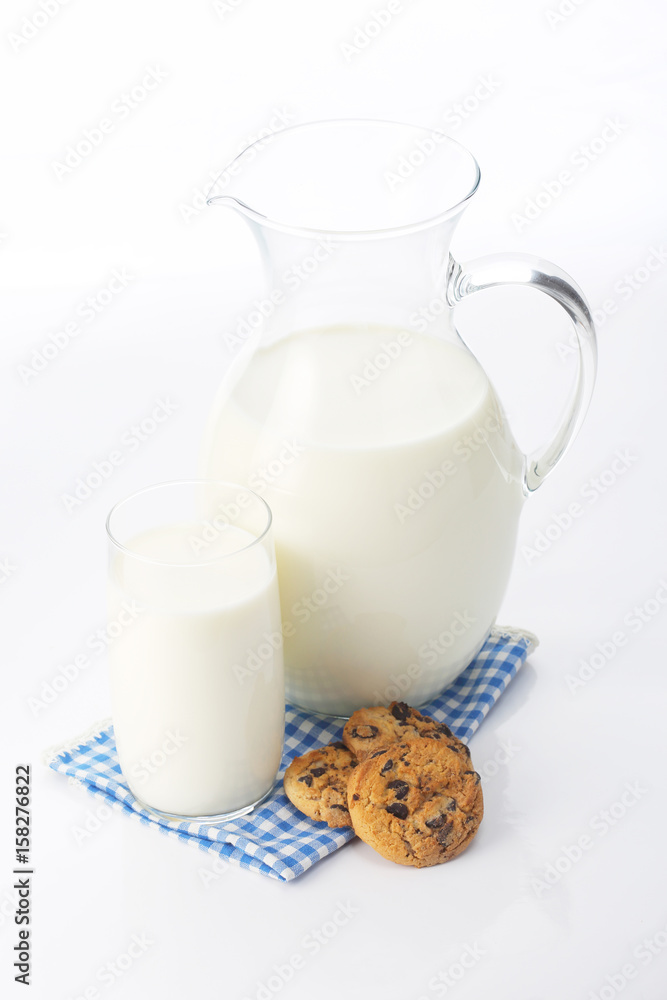 Pitcher and glass with some milk and cookies Pitcher and glass with some milk and cookies