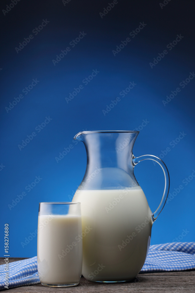 Jar and glass with some milk on blue Jar and glass with some milk on blue