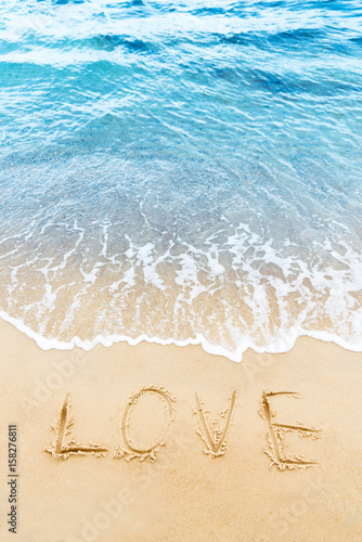 Love word written on the sand of the beach.