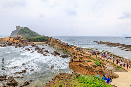 Tourists at the Yeliu (Yehliu) Geopark in Wanli District, New Taipei, Taiwan at a rainy, windy and overcast day photo