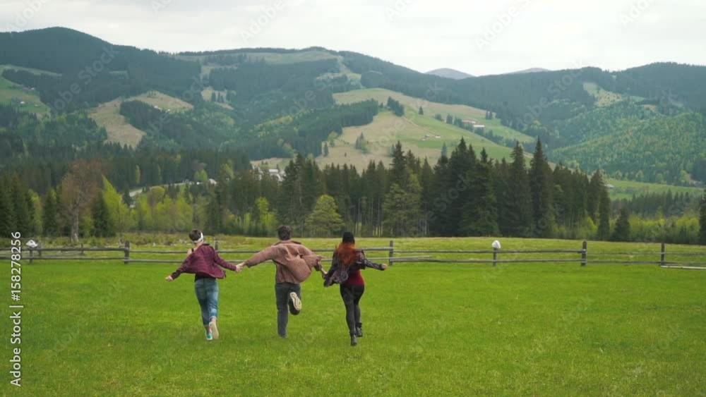 Tourists running holding hands in mountains valley. Tourists running holding hands in mountains valley.