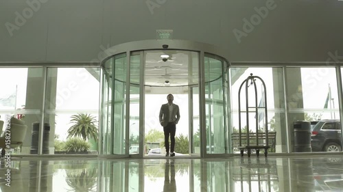 Man entering hotel lobby, slow motion