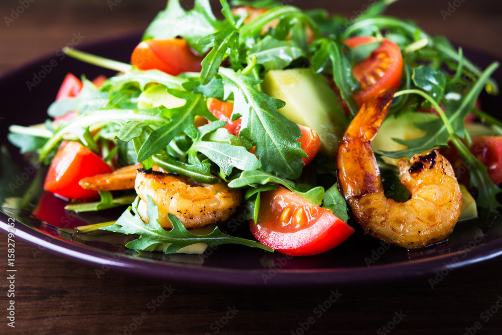 Fresh salad plate with shrimp, tomato, avocado and arugula (salad rocket) on wooden background close up. Healthy food. Clean eating. Fresh salad plate with shrimp, tomato, avocado and arugula (salad rocket) on wooden background close up. Healthy food. Clean eating.