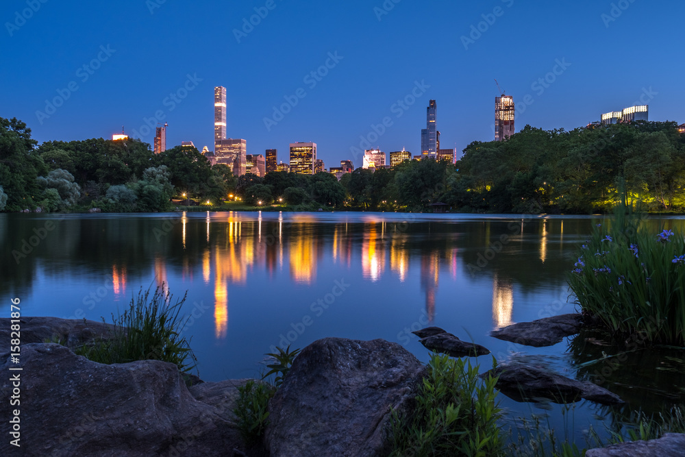Fototapeta premium Central Park Lake with view of Manhattan skyline at night