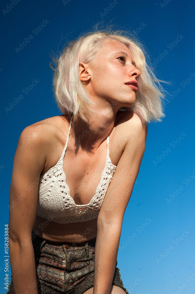 Naklejka premium Caucasian girl sunbathing on the sky background
