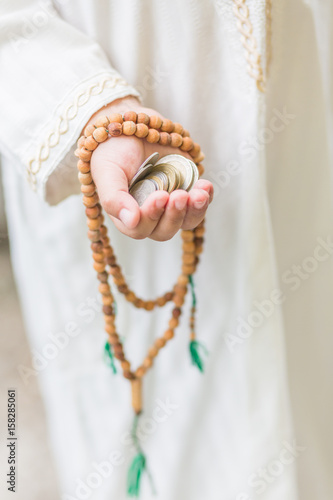 Islamic zakat or sadaka, adult giving money to child. photo