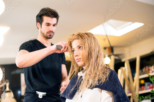 Attractive hairdresser making hair style