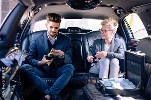 Business man and business woman in limousine