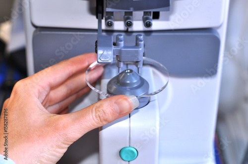 Fotografi Female optician measuring and preparing glasses,raw material on the digital devi