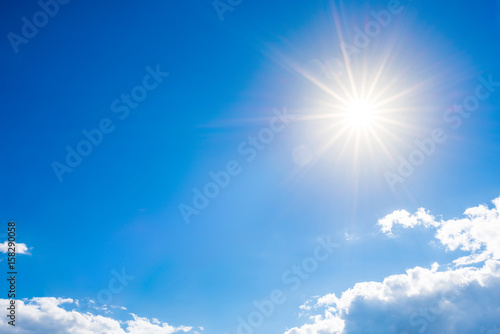 Sunny background, blue sky with clouds and bright sun