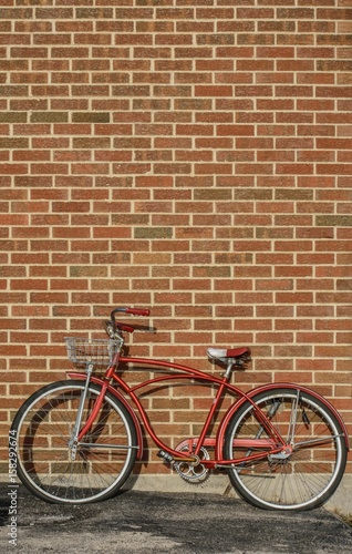 red retro bicycle leaning up against a brick wall