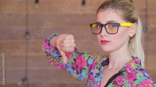 Thumbs down by attractive young women in glasses