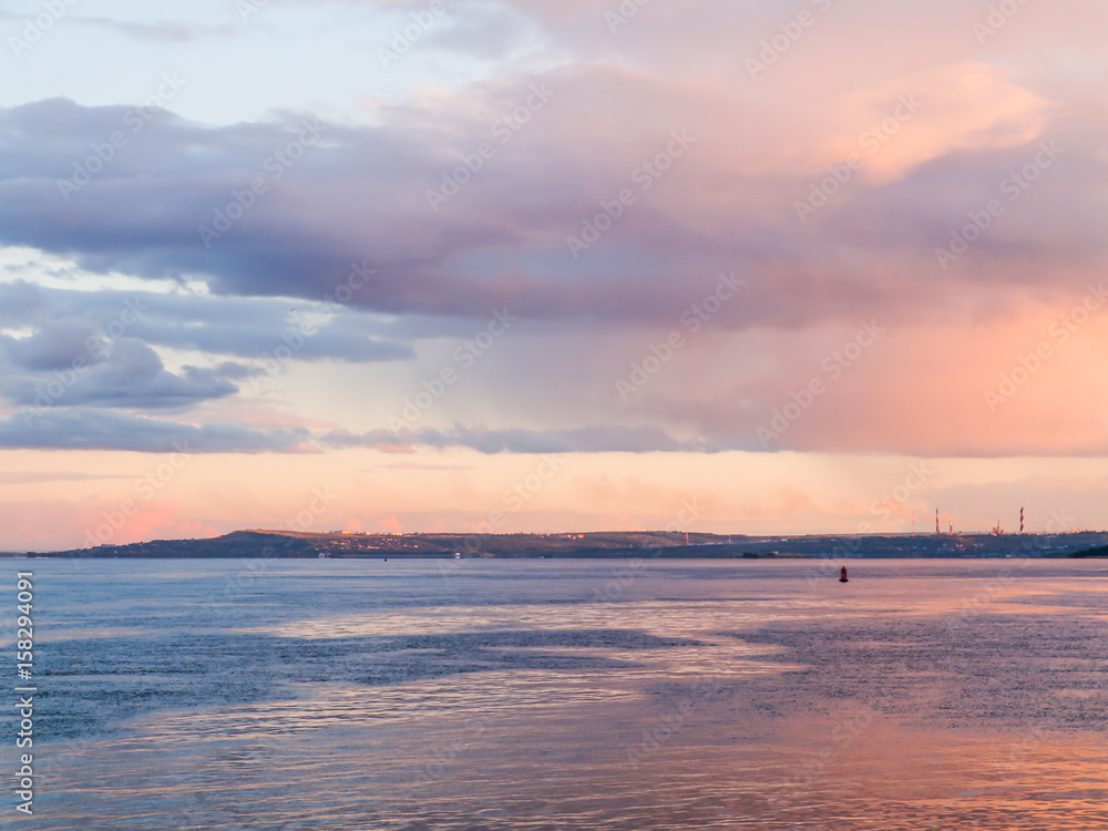 Scenic evening river landscape. Blue and pink sky at sunset. Russia, Saratov city, the Volga river.