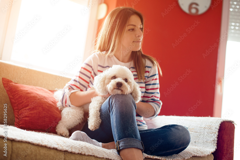 Young woman with dog on sofa Young woman with dog on sofa