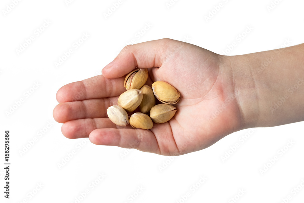 Roasted pistachios in the hands of the child isolated on white background. Roasted pistachios in the hands of the child isolated on white background.