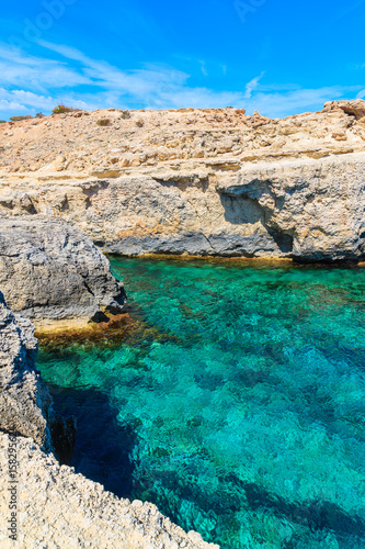 Rocks and sea cove with turquoise sea water in Cala Portinatx bay, Ibiza island, Spain