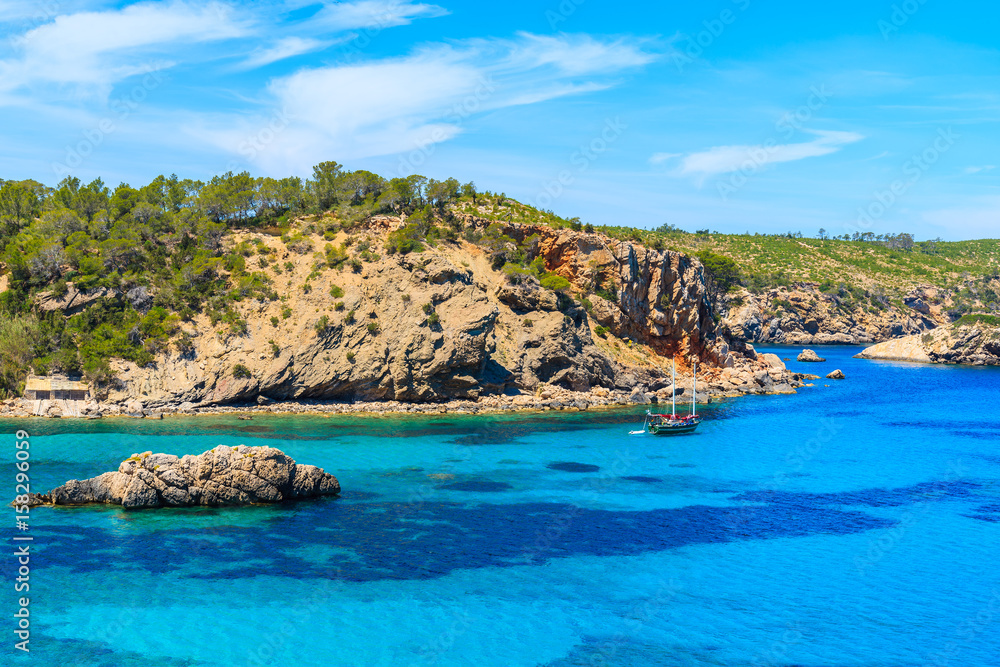 Sailboat on blue sea in Cala Xarraca bay on northern coast of Ibiza island, Spain