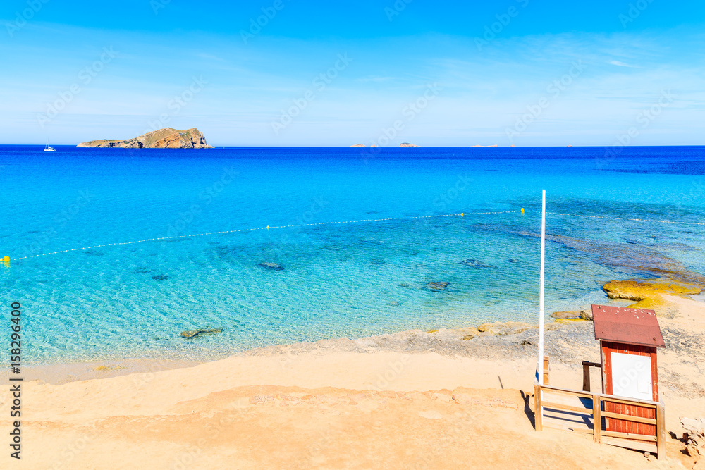 Lifeguard tower on beautiful Cala Comte beach famous for its azure crystal clear shallow sea water, Ibiza island, Spain