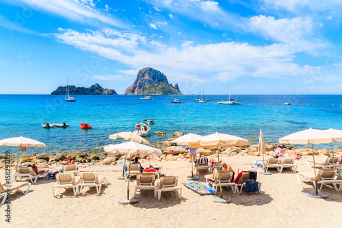 IBIZA ISLAND, SPAIN - MAY 18, 2017: Tourists sunbathing on idyllic beach of Cala d'Hort, Ibiza island, Spain.