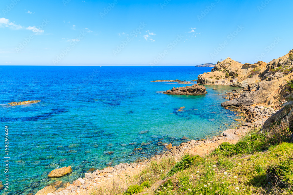 Blue sea water on coast of Ibiza island in Es Figueral bay, Spain