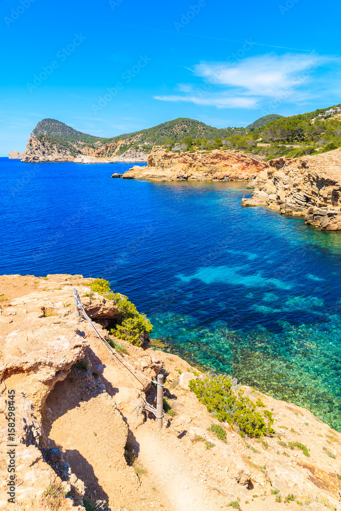 Blue sea water of Punta Galera bay surrounded by amazing stone formations, Ibiza island, Spain