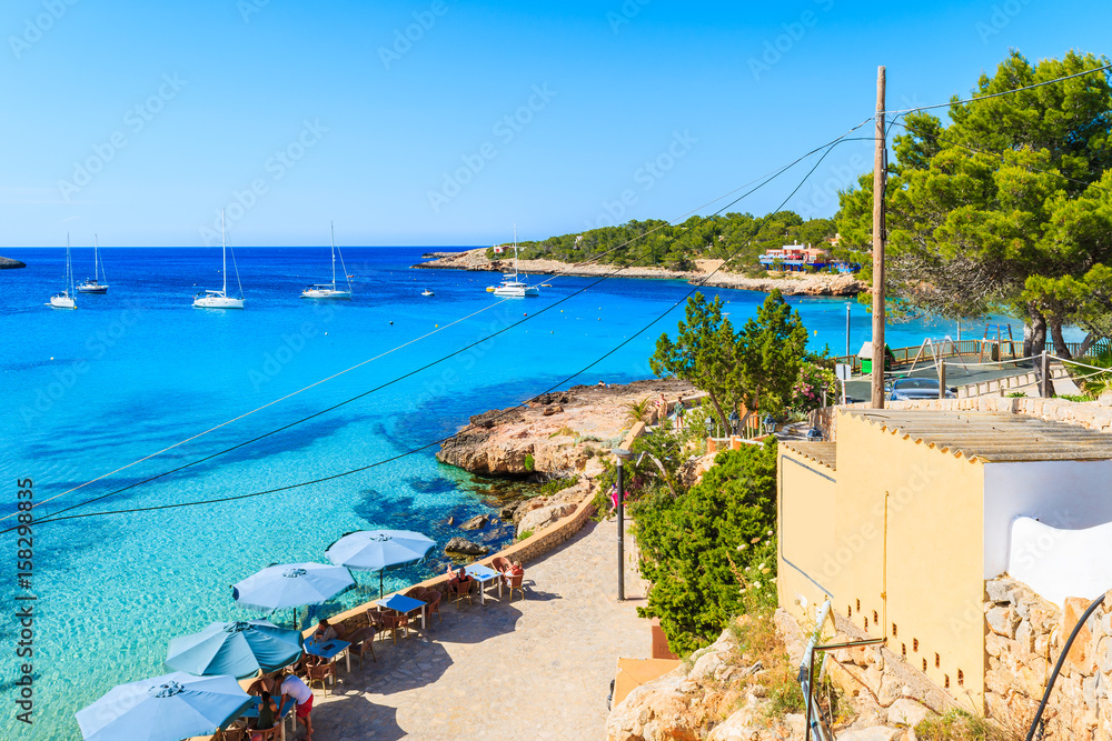 View of coastal promenade along beach in Cala Portinatx, Ibiza island, Spain