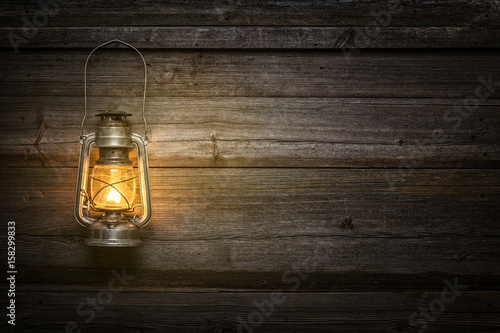 The old kerosene lamp on wooden background