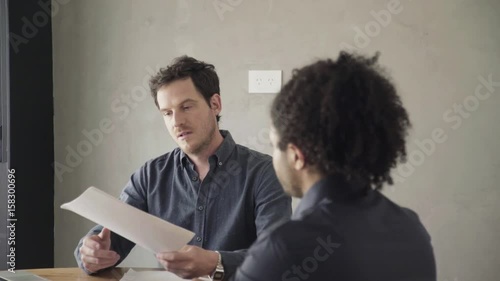 Man reviewing document and listening to explanation photo