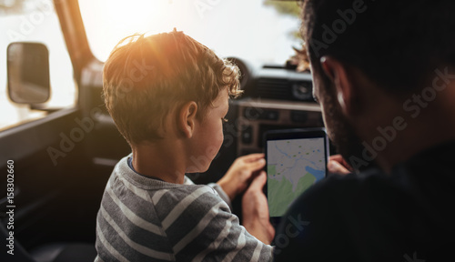 Father and son planning the route of a road trip © Jacob Lund