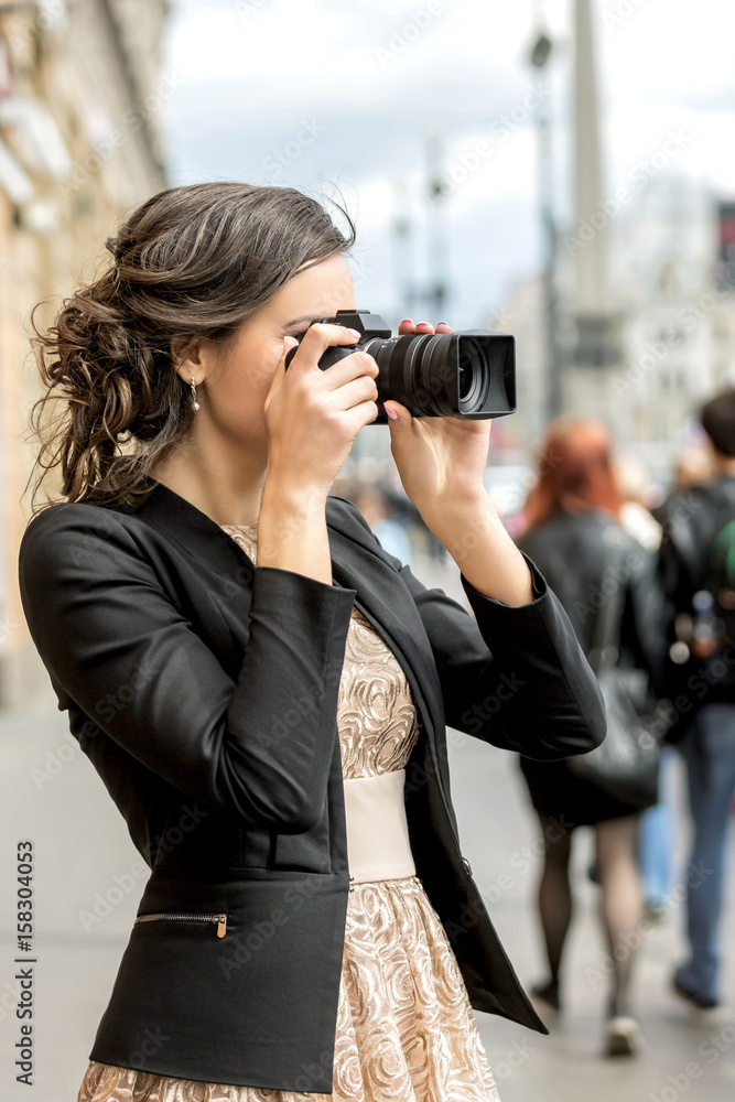 Young woman takes pictures on a city street