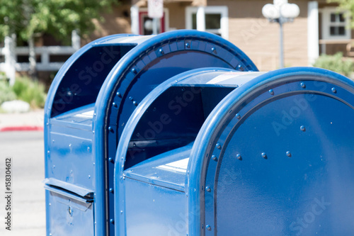 Two blue roadside mailboxes