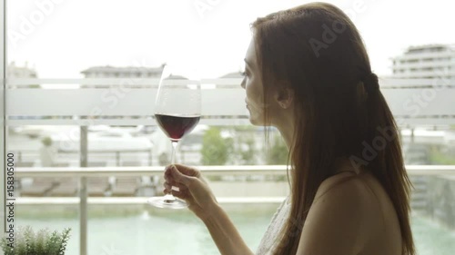 Woman enjoying glass of red wine, slow motion photo