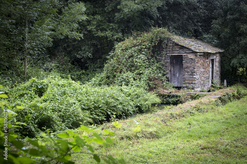 ancient stone made house and a water stream in the woods