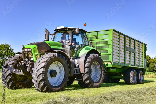 Ernte - Landtechnik - Einfahren der Grassilage mit Traktor und Ladewagen